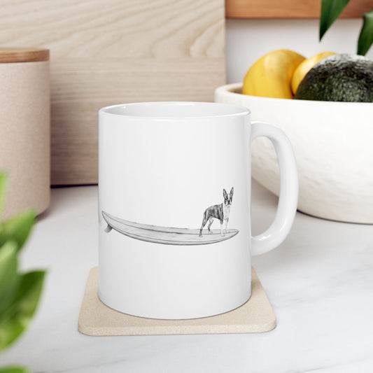 White mug with a design of a Boston Terrier on a longboard on a white backgroud.