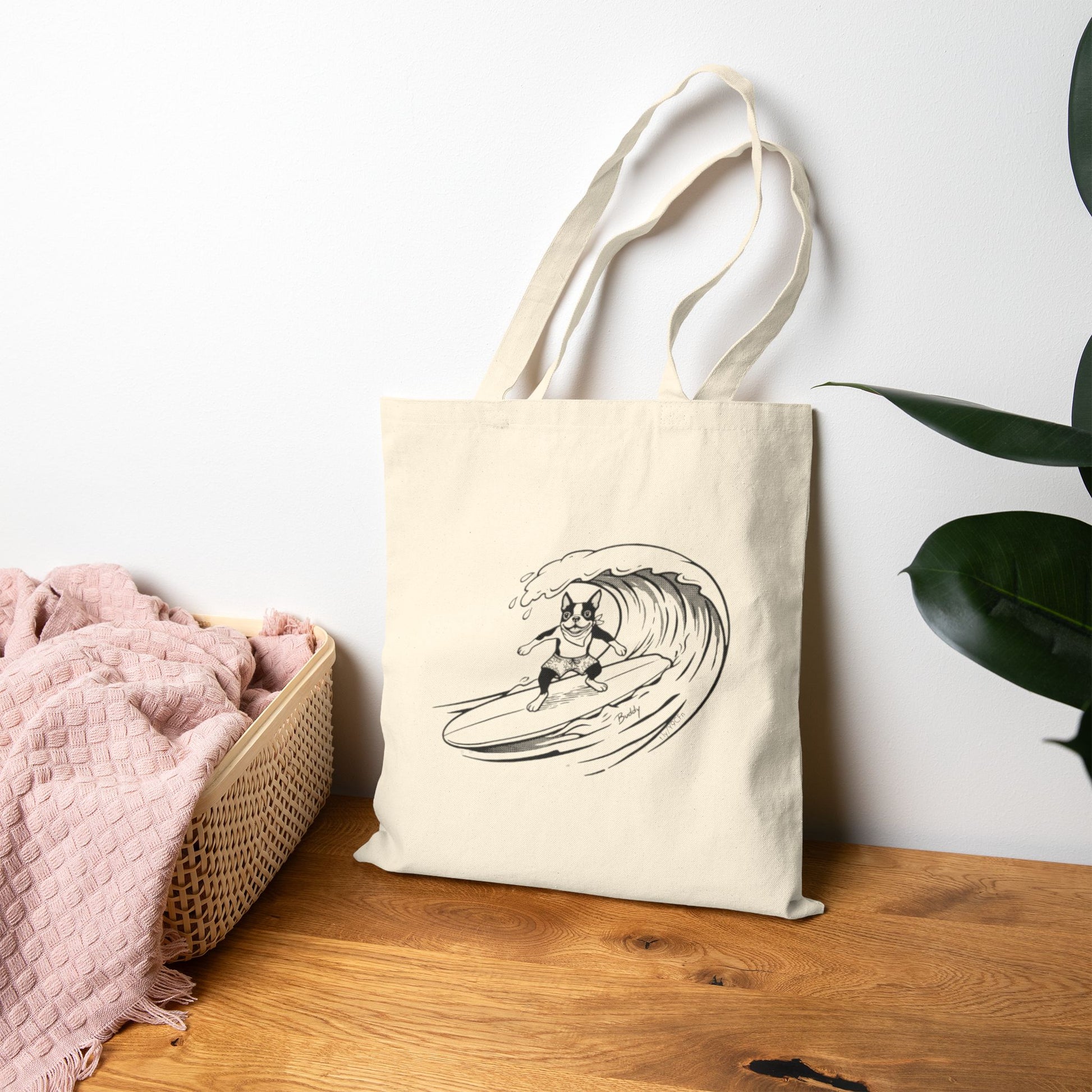Beige tote bag with a graphic of a boston terrier riding a big wave on a longboard with a beige background.