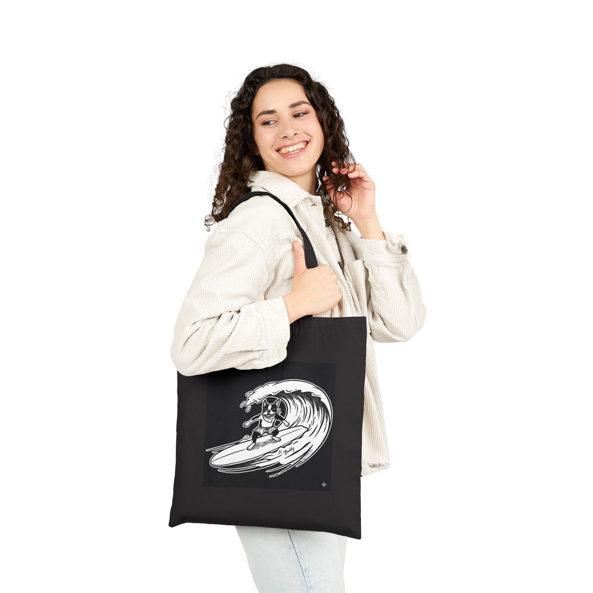 Woman holding a Black tote bag with a graphic of a boston terrier riding a big wave on a longboard with a black background.