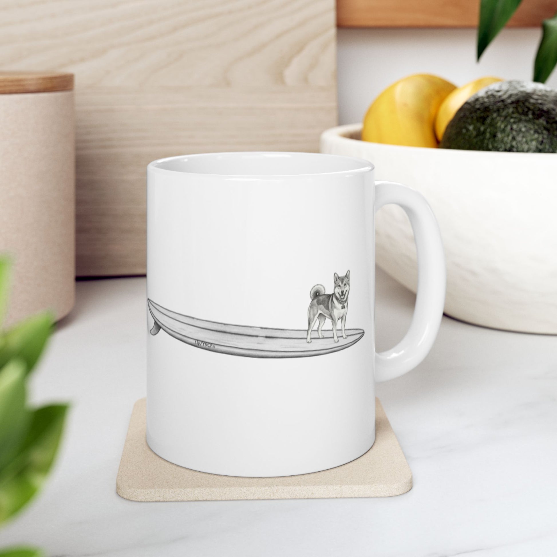 White mug with a design of a Shiba Inu dog hanging twenty on a long surfboard on a white background