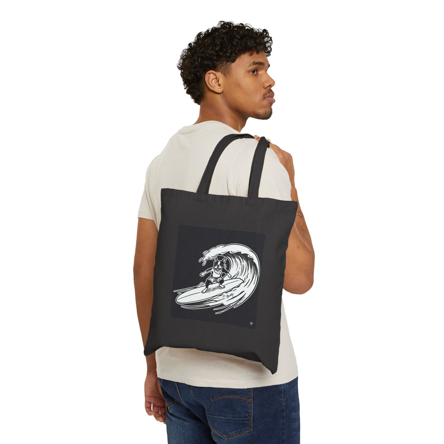 Man carrying a Black tote bag with a graphic of a boston terrier riding a big wave on a longboard with a black background.