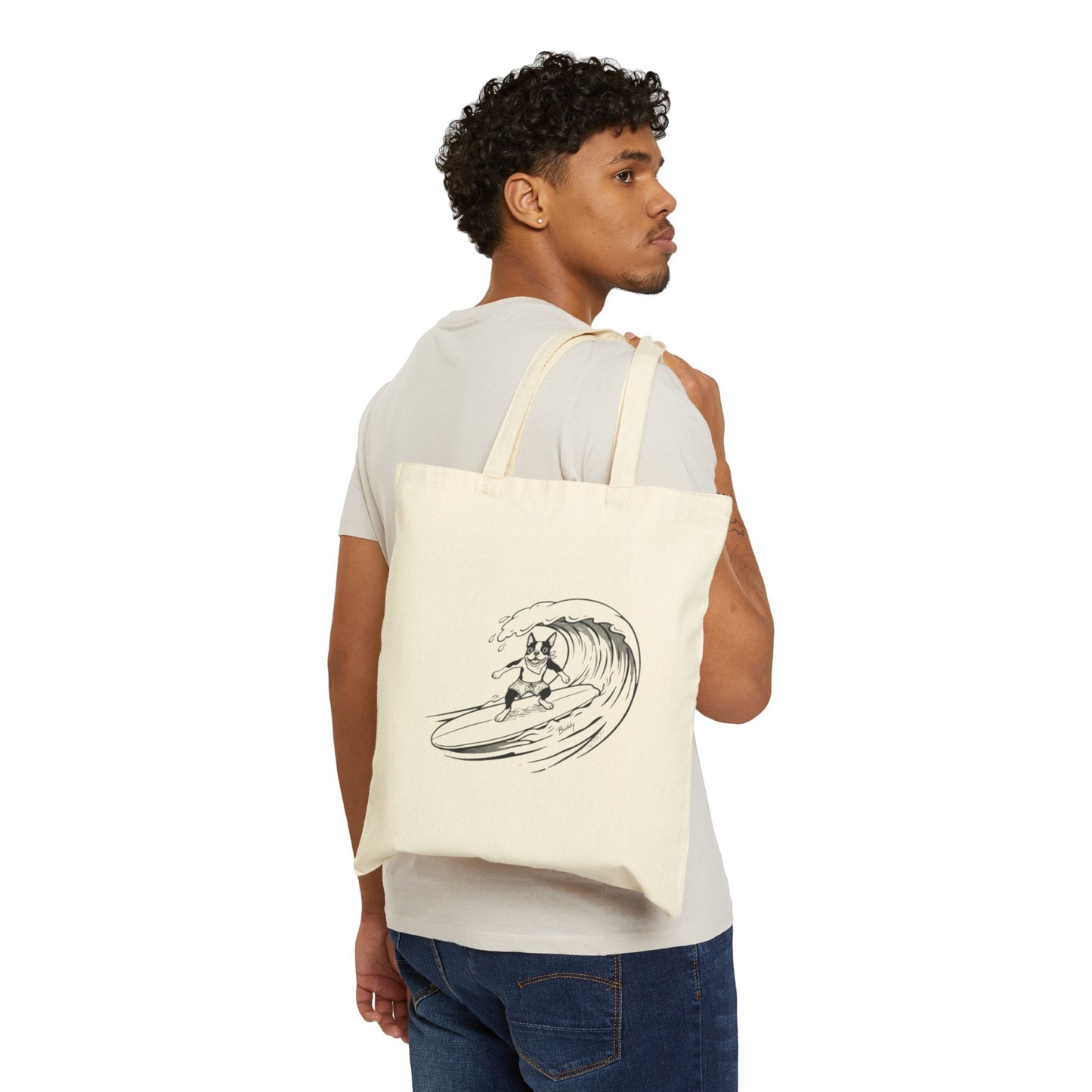 Man carrying a Beige tote bag with a graphic of a boston terrier riding a big wave on a longboard with a beige background.