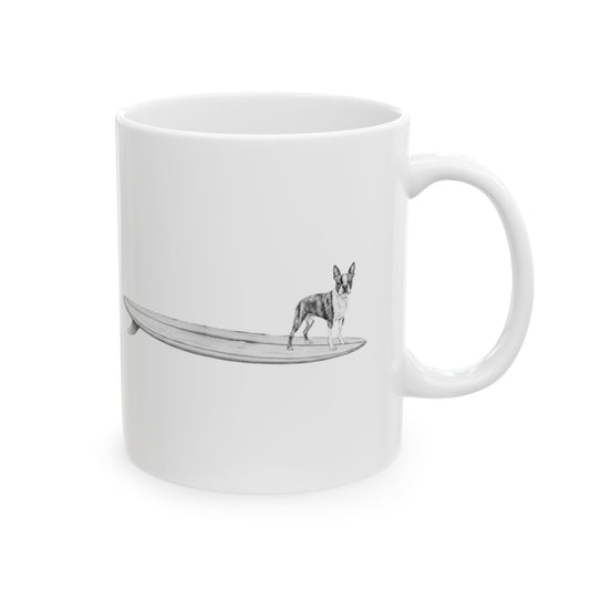 White mug with a design of a  Boston Terrier on a longboard on a white backgroud.