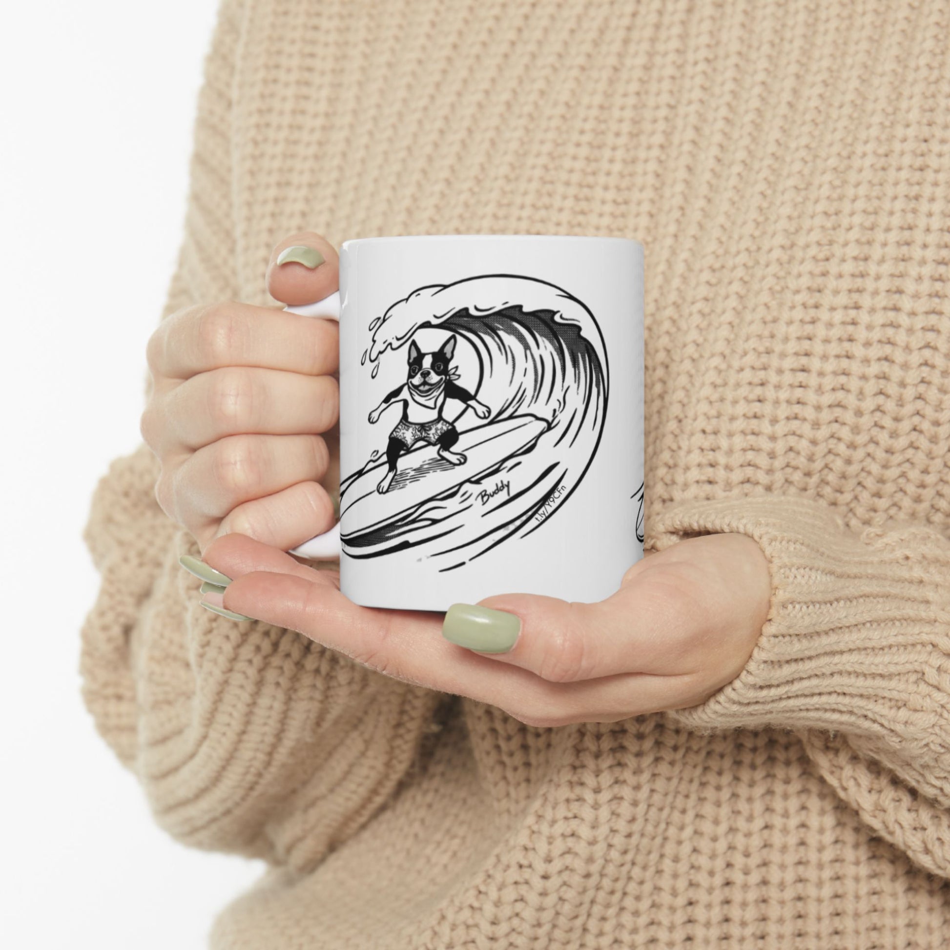 White mug with a black and white graphic of a Boston Terrier surfing on a big wave with a white background.