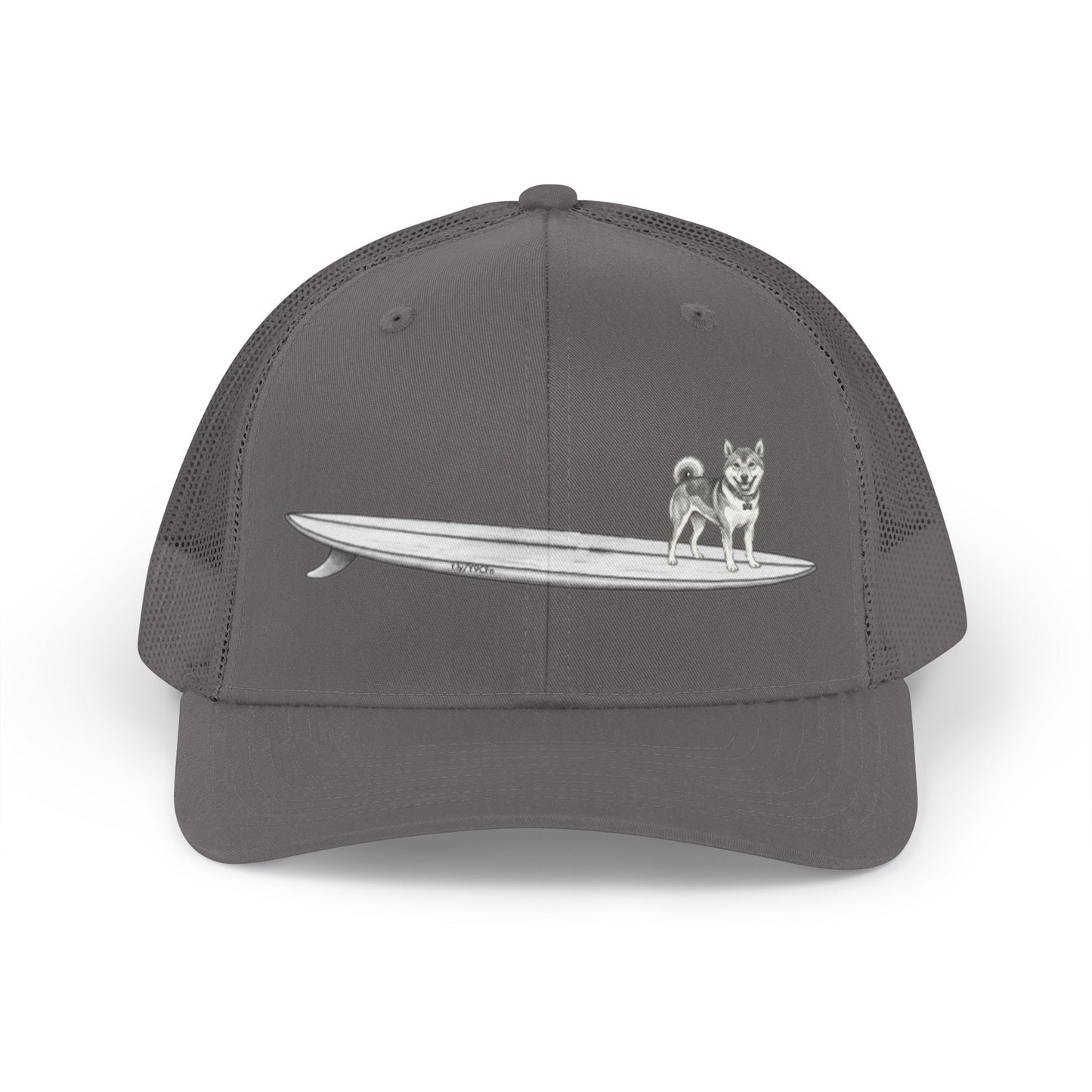 Gray  mesh trucker hat with a graphic of a Shiba Inu dog hanging twenty on a long  surfboard design on a gray background