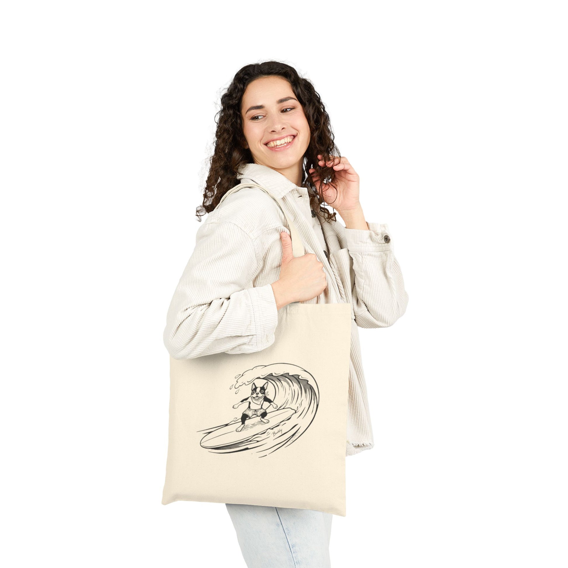 Woman holding a Beige tote bag with a graphic of a boston terrier riding a big wave on a longboard with a beige background.