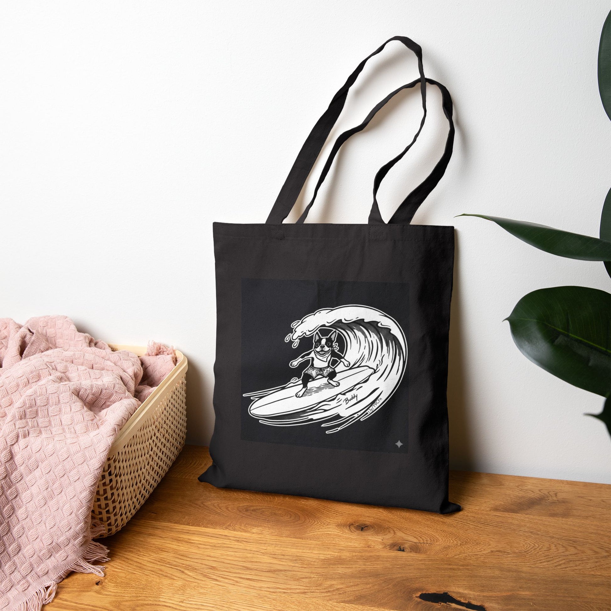 Black tote bag with a graphic of a boston terrier riding a big wave on a longboard with a black background.