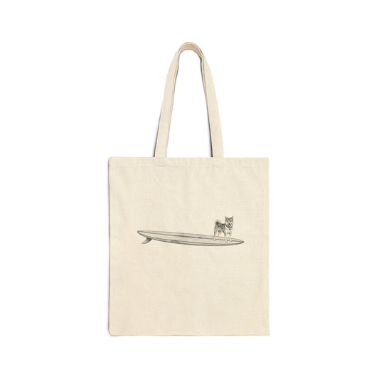 Beige tote bag with a design of a Shiba Inu dog hanging twenty on a long surfboard on a beige background
