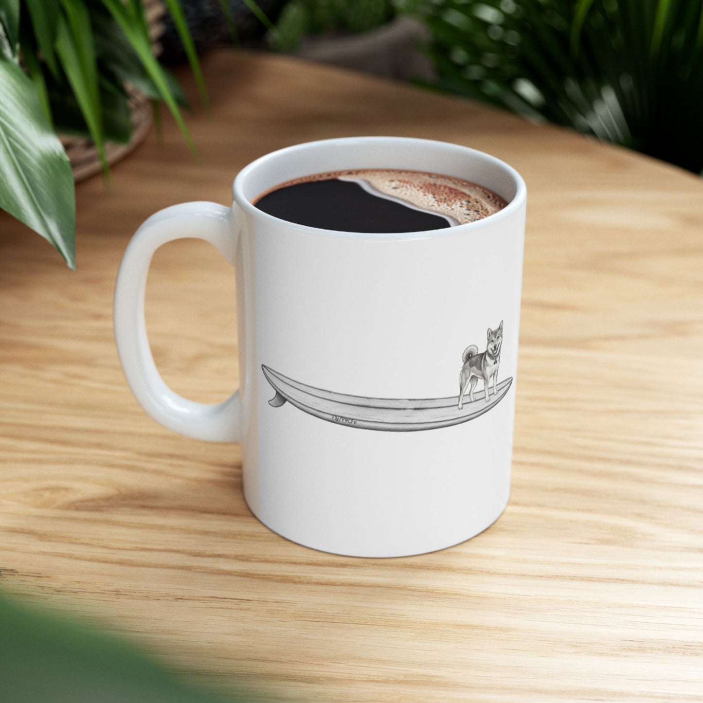 White mug with a design of a Shiba Inu dog hanging twenty on a long surfboard on a white background